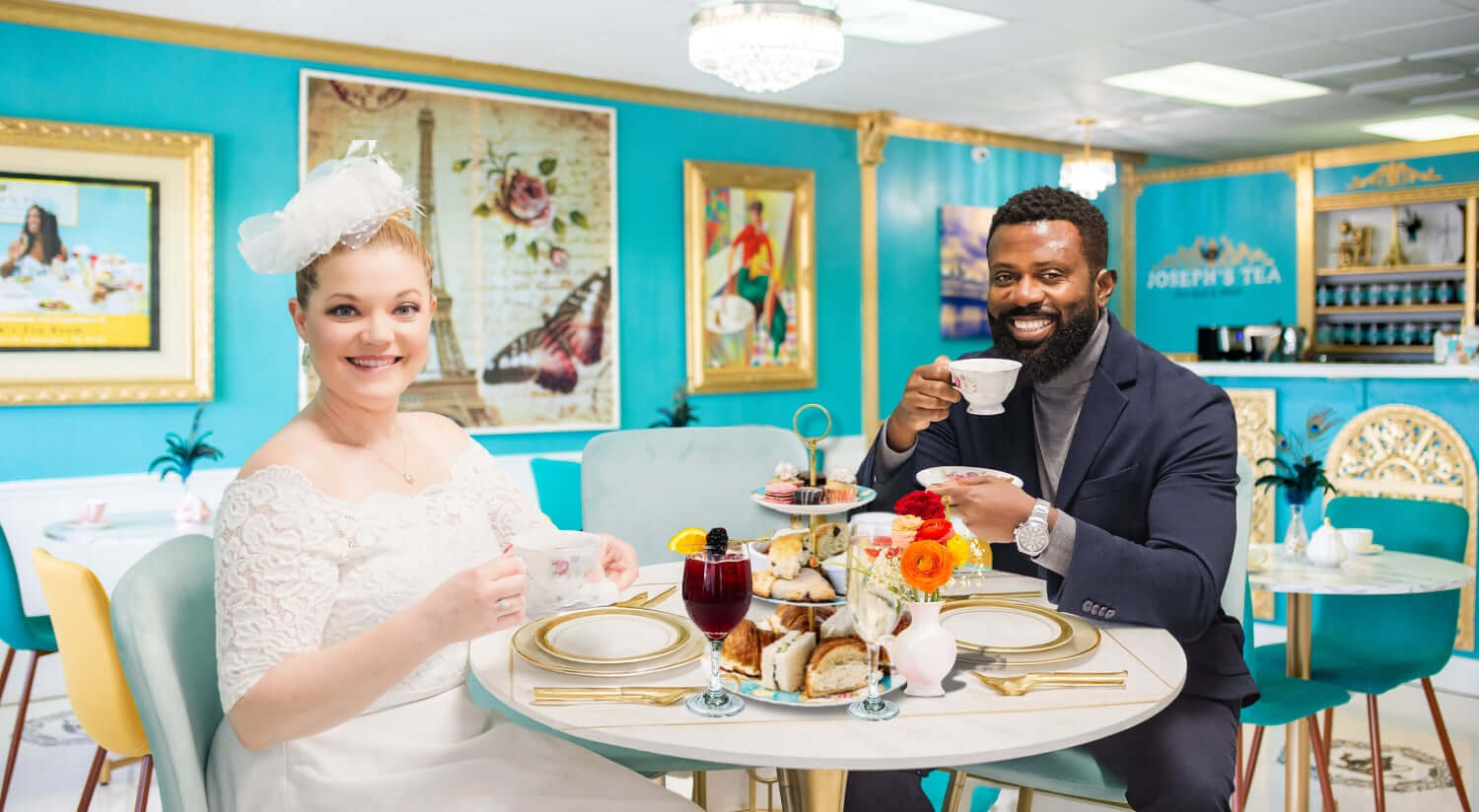 The founders enjoying afternoon tea in a stylish cafe with blue walls and decorative elements.
